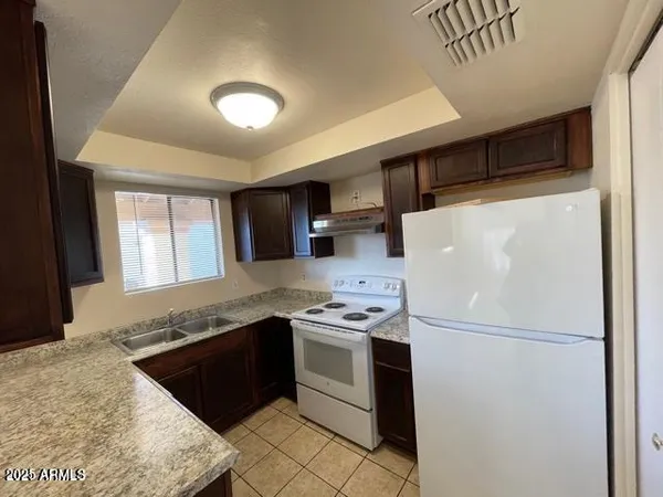 a kitchen with stainless steel appliances granite countertop a refrigerator a stove a sink and a microwave