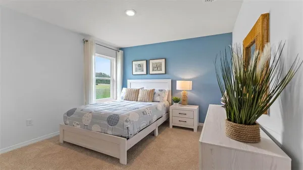 a bedroom with a bed and large window