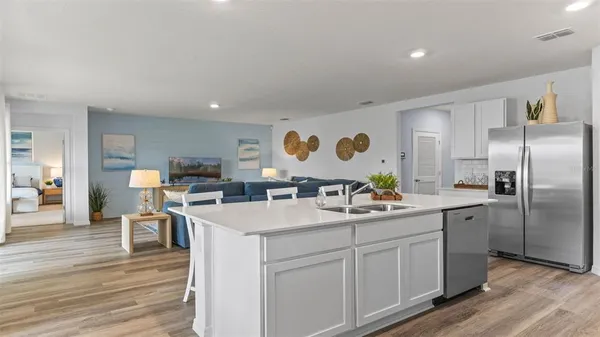 a kitchen with a sink cabinets and wooden floor