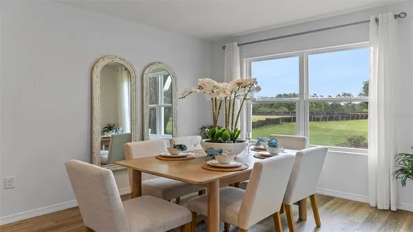 a kitchen with a dining table a stove a dining table and chairs with wooden floor