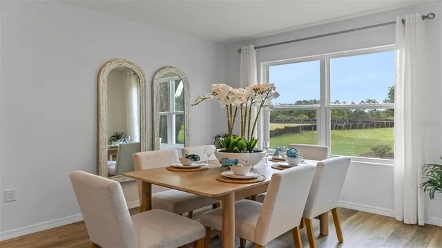 a kitchen with a dining table a stove a dining table and chairs with wooden floor