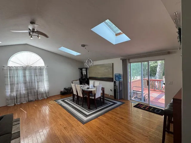 a living room with furniture large window and wooden floor