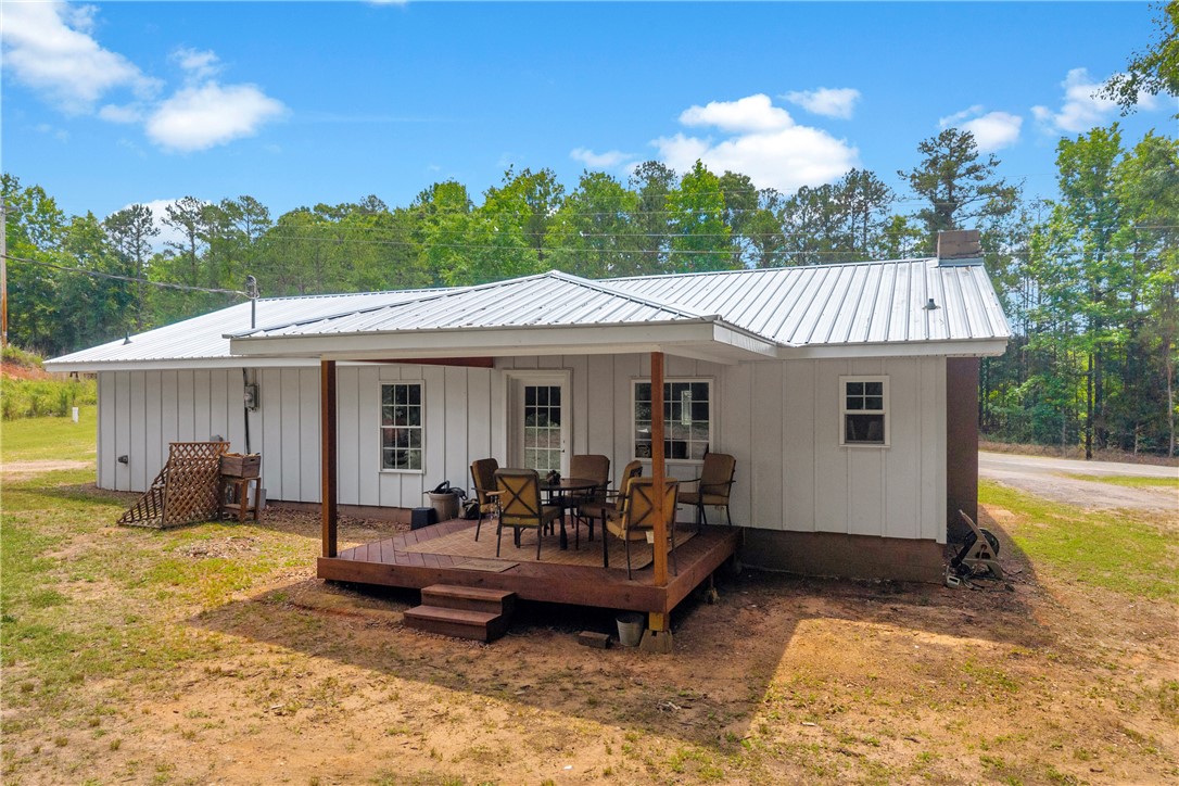 3030 Smith McGee Road Iva, SC 29655 - Photo 3 of 46 A quaint rear deck offers a private outdoor dining spot against a serene wooded backdrop.