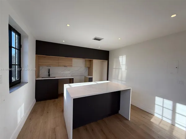 a living room with stainless steel appliances kitchen island a fireplace wooden floor and living room