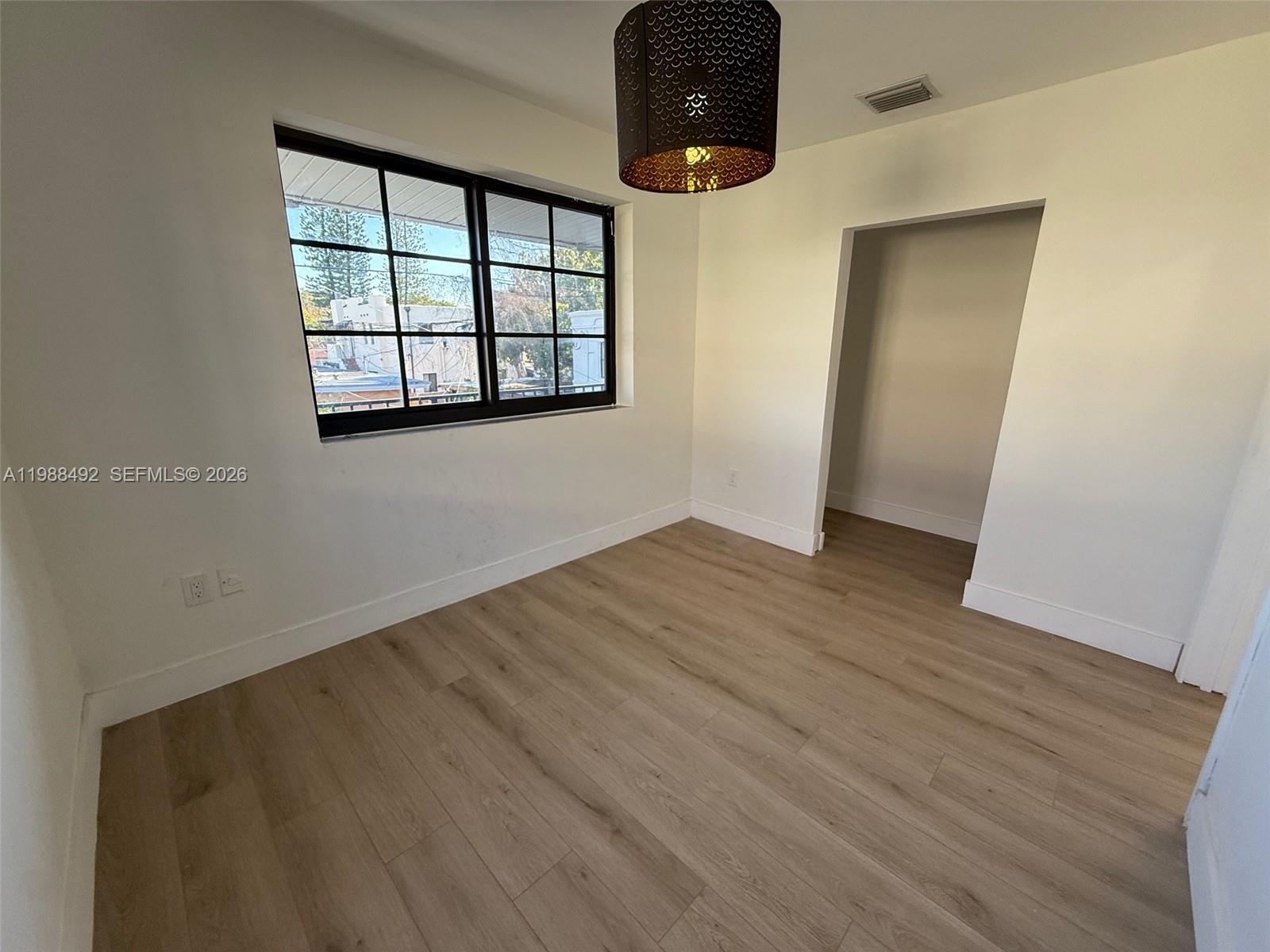 1716 Southwest 11th Street, Unit 4 Miami, FL 33135 - Photo 8 of 11 an empty room with wooden floor and windows