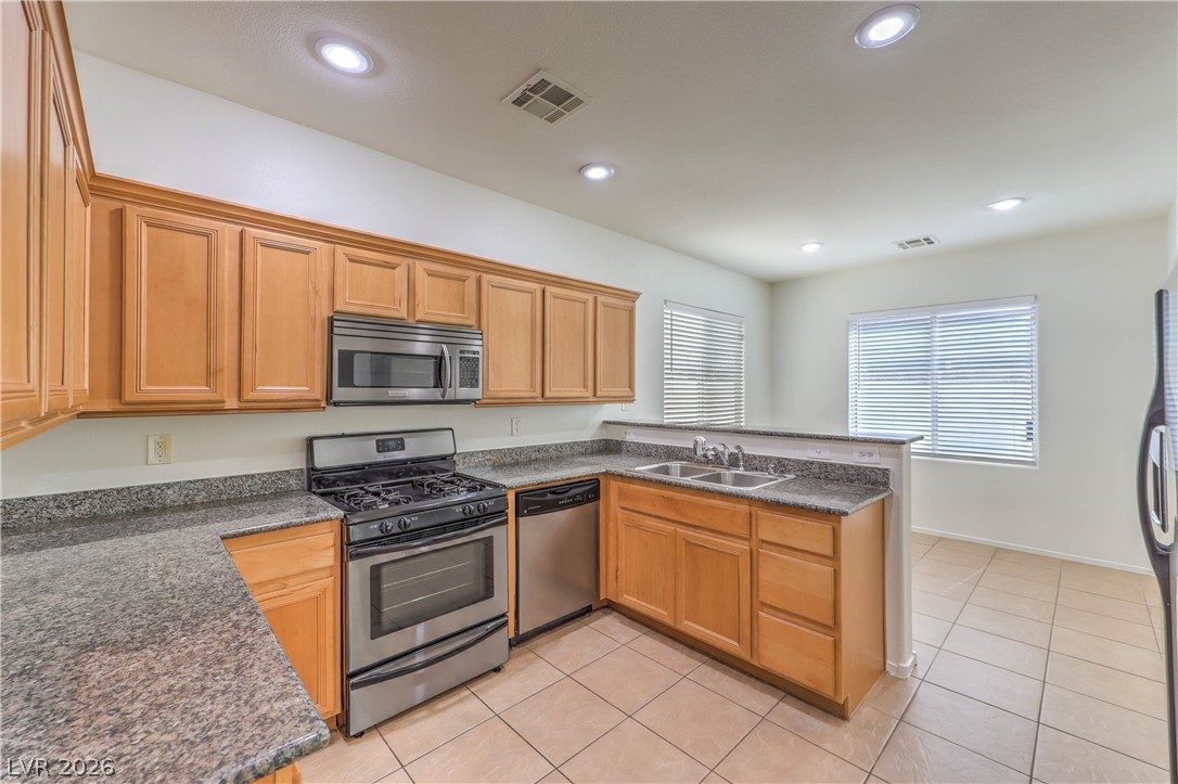 10939 Paradise Road Henderson, NV 89052 - Photo 7 of 36 A well-equipped kitchen features ample cabinetry and sleek stainless steel appliances, inviting culinary creativity.