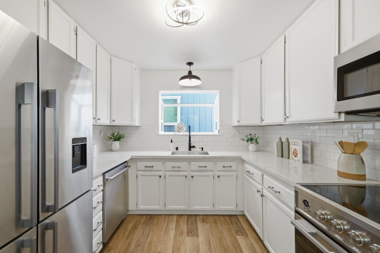 495 Ebken Street Pacifica, CA 94044 - Photo 17 of 52 a kitchen with a sink dishwasher a white refrigerator and cabinets