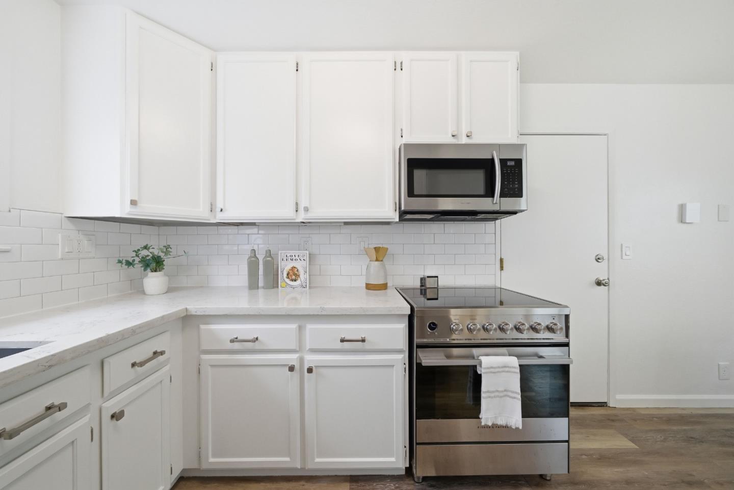 495 Ebken Street Pacifica, CA 94044 - Photo 21 of 52 a kitchen with stainless steel appliances granite countertop white cabinets a sink a stove and a microwave