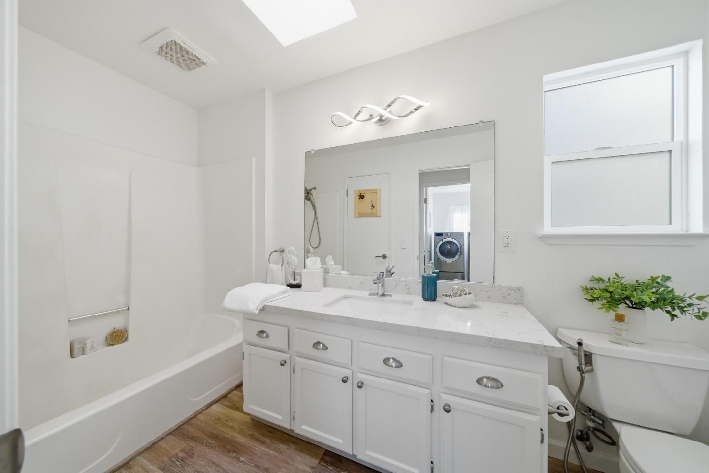 495 Ebken Street Pacifica, CA 94044 - Photo 38 of 52 a bathroom with a double vanity sink a mirror and a bathtub