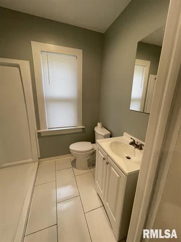 2228 9th Street Rock Island, IL 61201 - Photo 6 of 10 a bathroom with a sink a toilet and a mirror