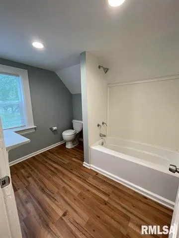 a spacious bathroom with a bathtub and a toilet