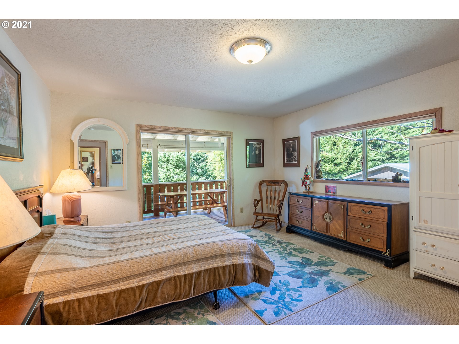 8715 Scholfield Road North Bend, OR 97459 - Photo 12 of 32 a bedroom with a bed next to a window