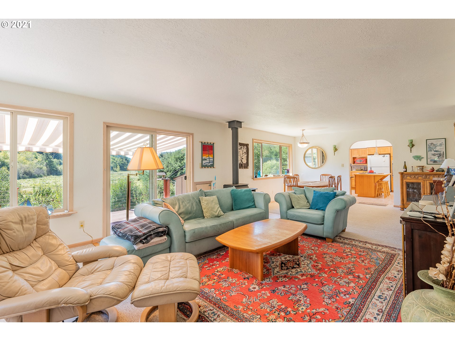 8715 Scholfield Road North Bend, OR 97459 - Photo 4 of 32 a living room with furniture a rug and a floor to ceiling window