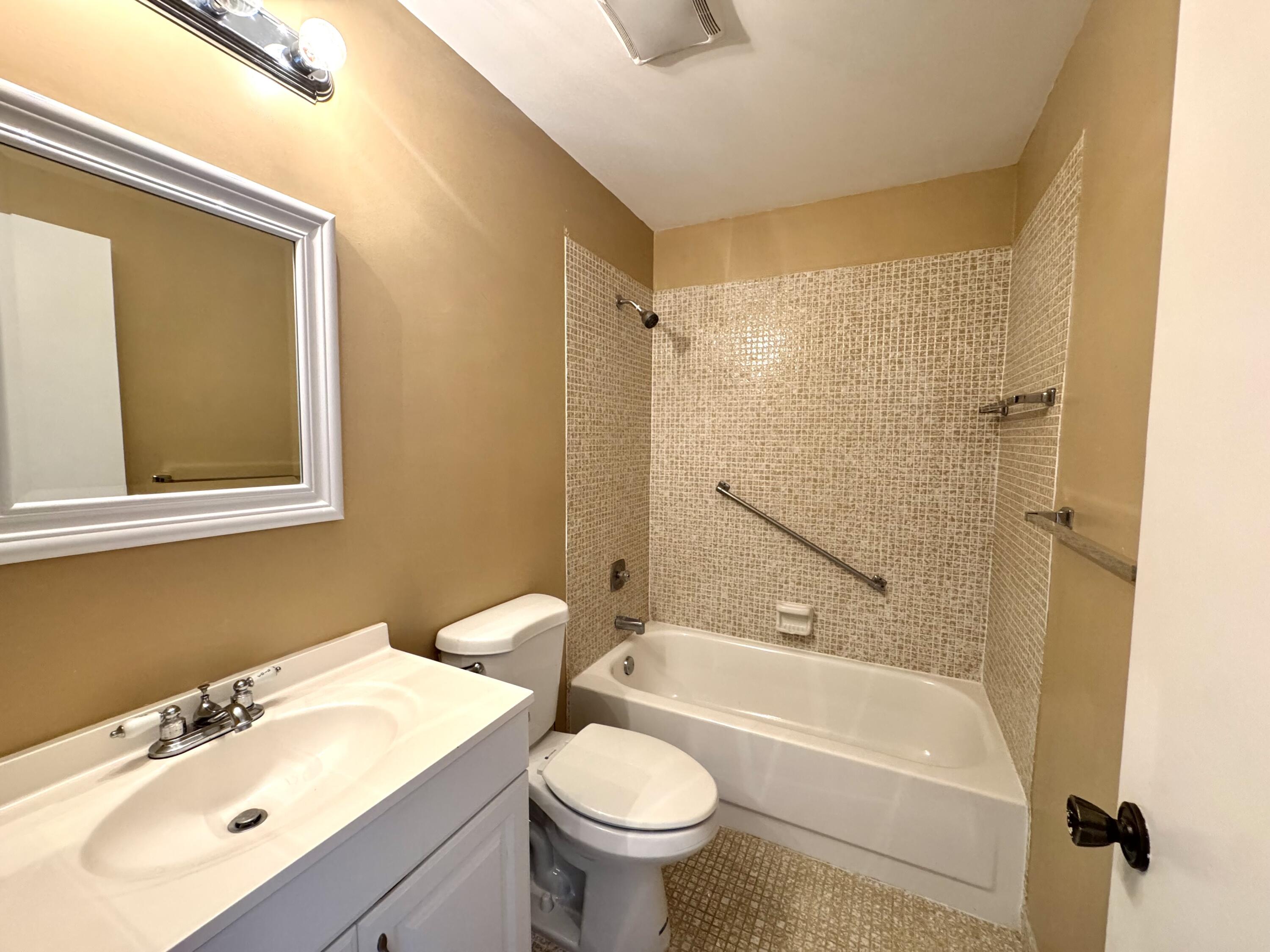 900 Normandy Lane Delray Beach, FL 33484 - Photo 12 of 22 a bathroom with a sink mirror toilet and bathtub