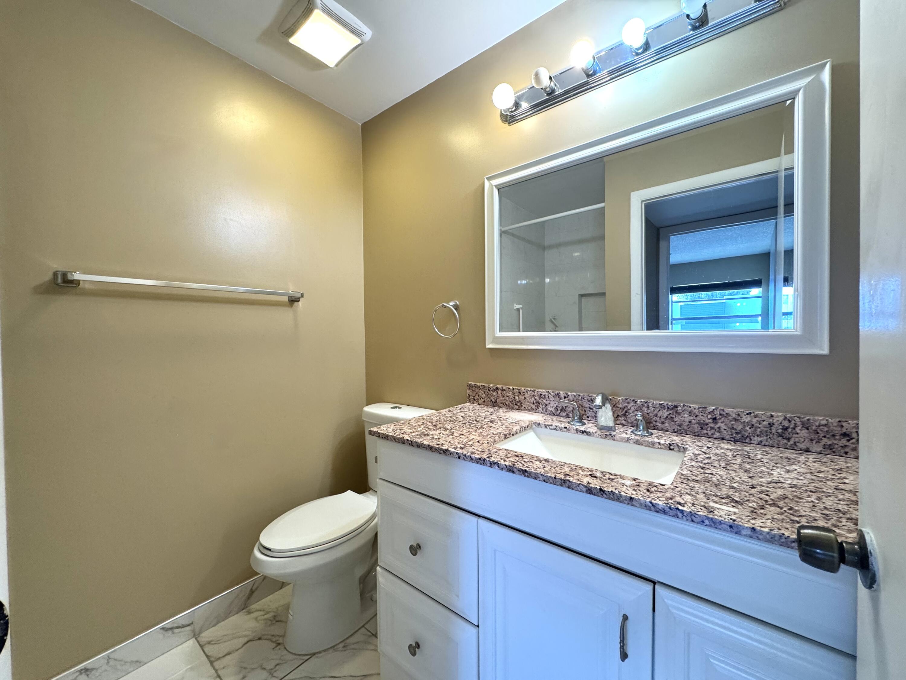 900 Normandy Lane Delray Beach, FL 33484 - Photo 15 of 22 a bathroom with a granite countertop sink mirror vanity and toilet