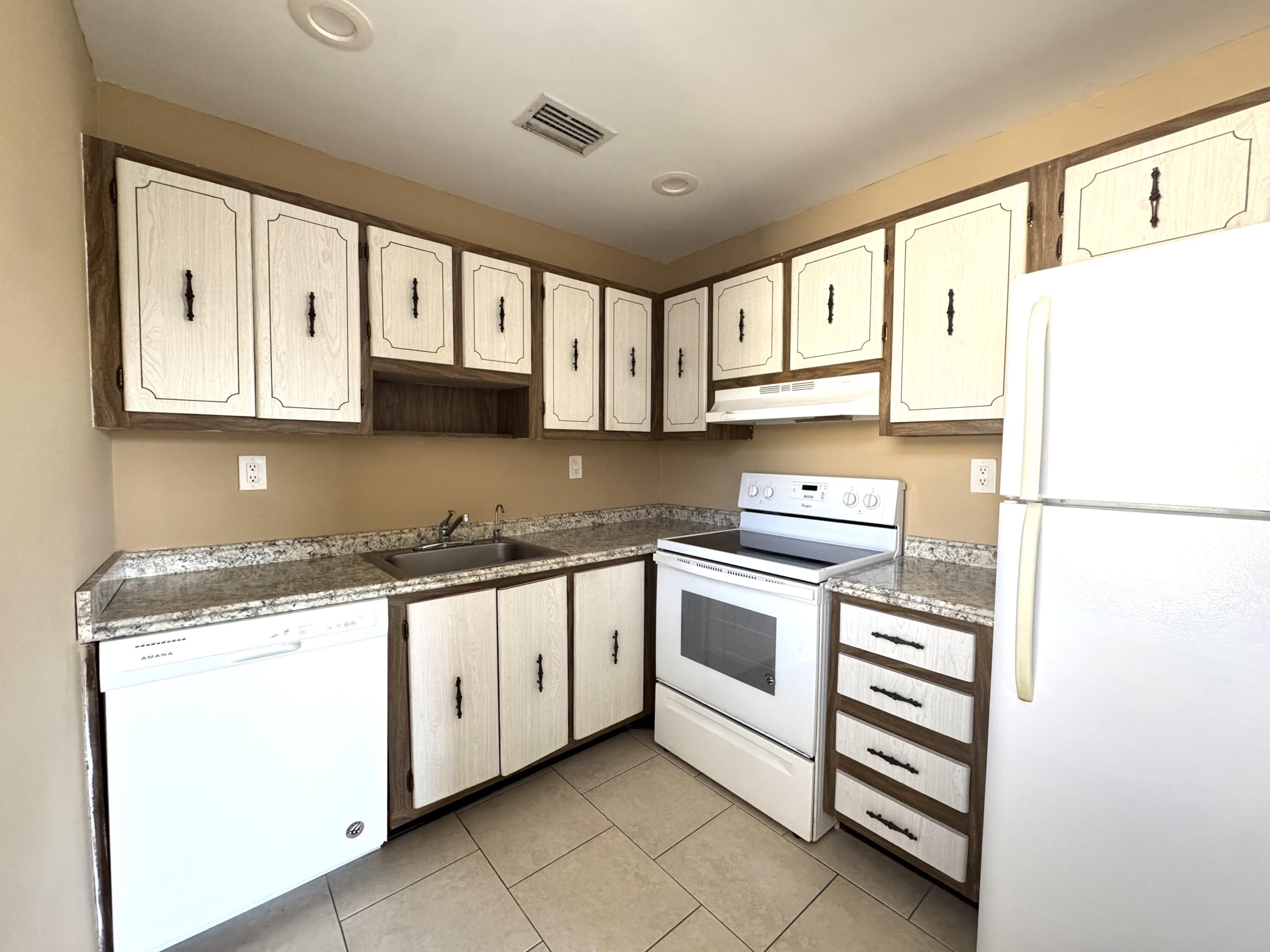 900 Normandy Lane Delray Beach, FL 33484 - Photo 7 of 22 a kitchen with granite countertop cabinets stainless steel appliances and a sink