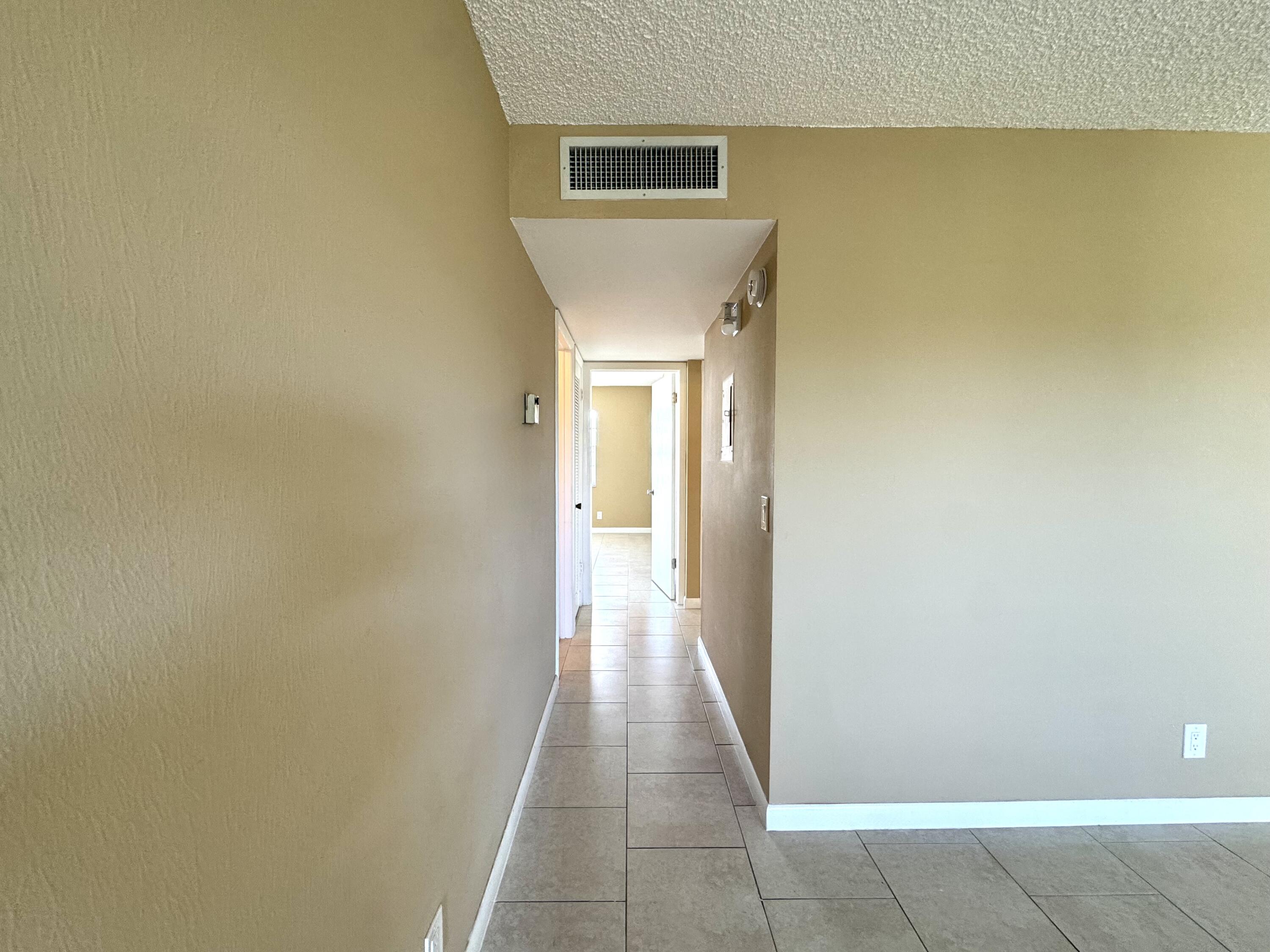 900 Normandy Lane Delray Beach, FL 33484 - Photo 10 of 22 a view of a hallway with wooden floor