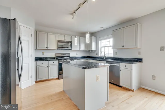 a kitchen with stainless steel appliances granite countertop a sink and a microwave