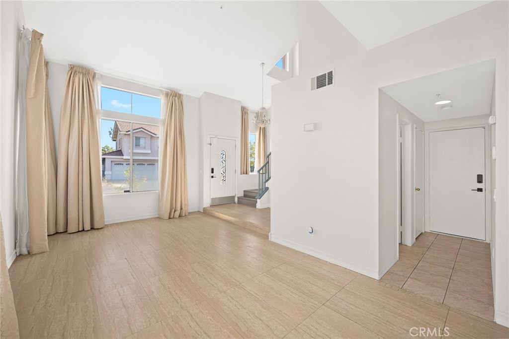 7190 Trivento Place Rancho Cucamonga, CA 91701 - Photo 3 of 13 a view of an empty room with wooden floor and a bathroom