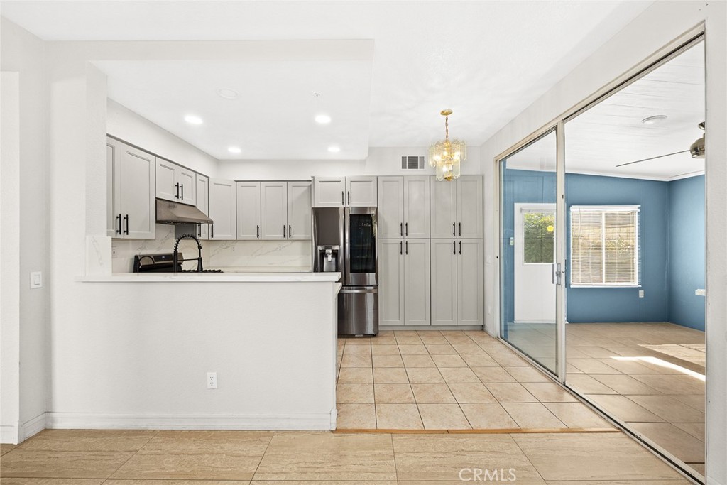7190 Trivento Place Rancho Cucamonga, CA 91701 - Photo 5 of 13 a large white kitchen with white cabinets and refrigerator