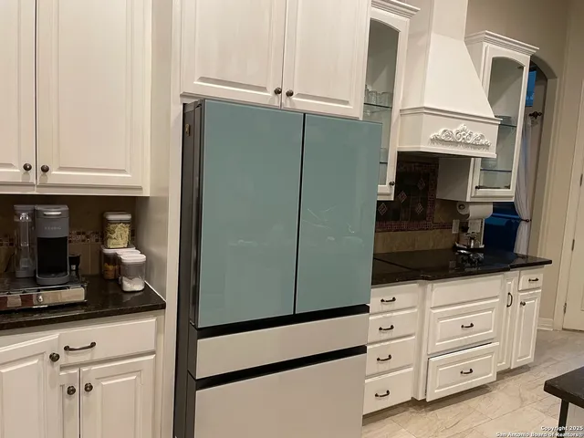 a kitchen with cabinets and a refrigerator