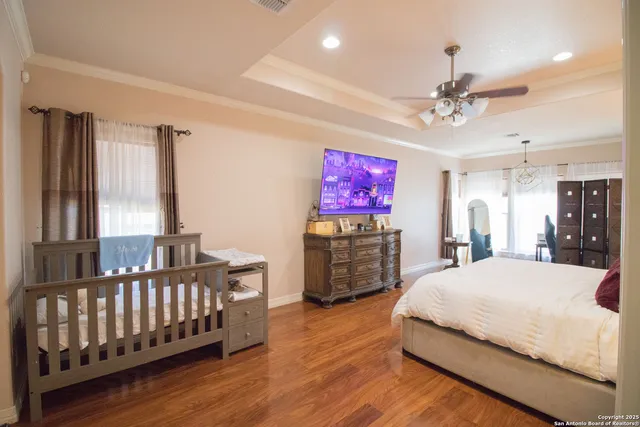 a spacious bedroom with a bed and a flat screen tv