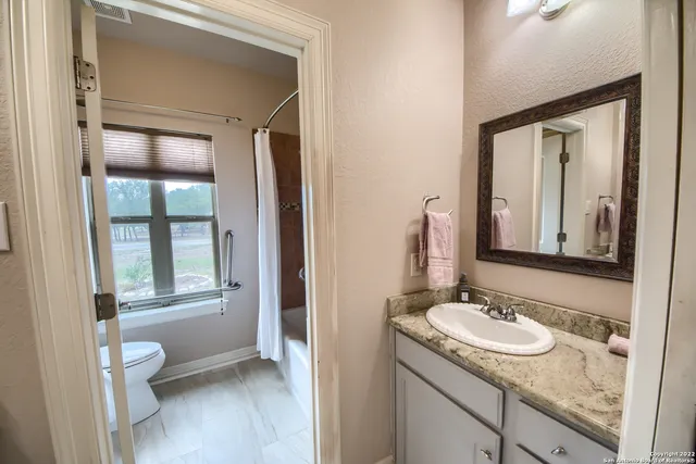 a bathroom with a granite countertop sink and a mirror