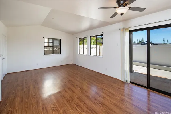 a view of an empty room with a window and wooden floor