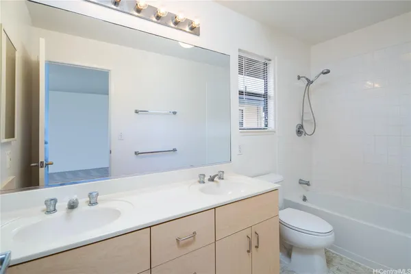 a bathroom with a granite countertop sink a toilet and shower