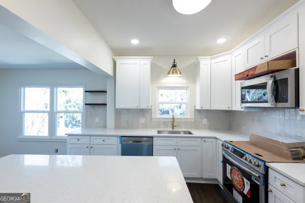 a kitchen that has a sink and a stove in it
