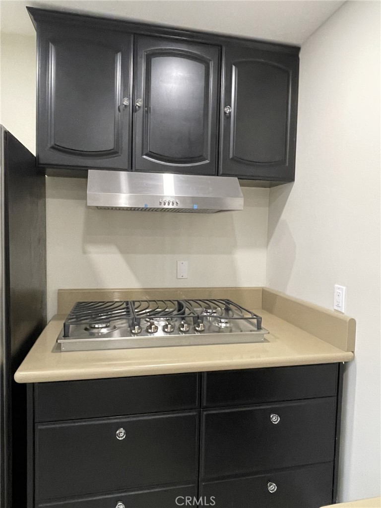 5700 Etiwanda Avenue, Unit 240 Los Angeles, CA 91356 - Photo 5 of 39 a view of kitchen island with wooden cabinets