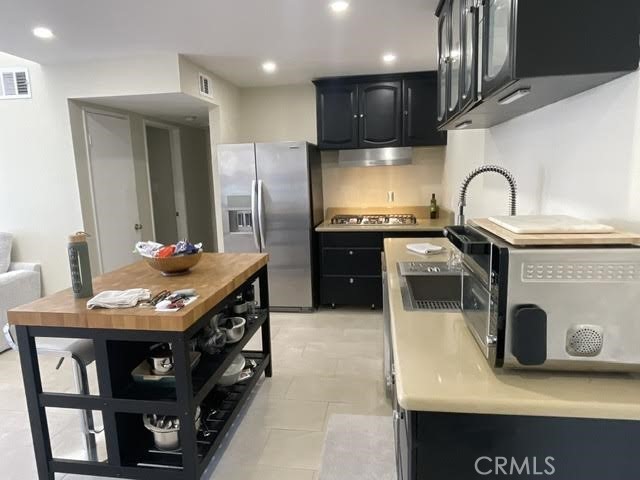 5700 Etiwanda Avenue, Unit 240 Los Angeles, CA 91356 - Photo 6 of 39 a kitchen with stainless steel appliances granite countertop a sink a stove and a refrigerator