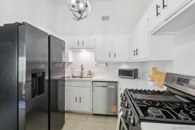 a kitchen with stainless steel appliances a stove a sink and cabinets
