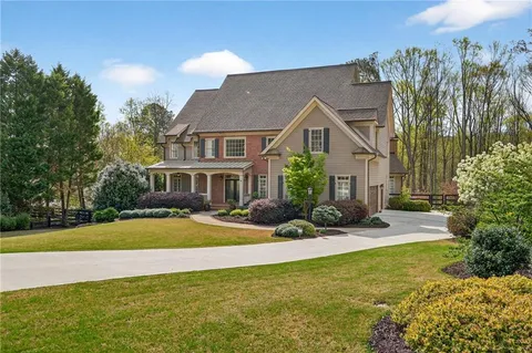 a front view of a house with yard and green space
