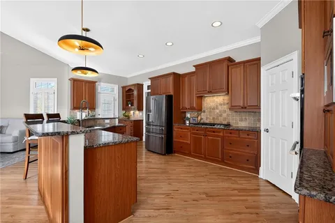 a kitchen with granite countertop a sink stove and cabinets