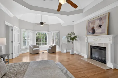 a spacious bedroom with a bed a couch and a large window