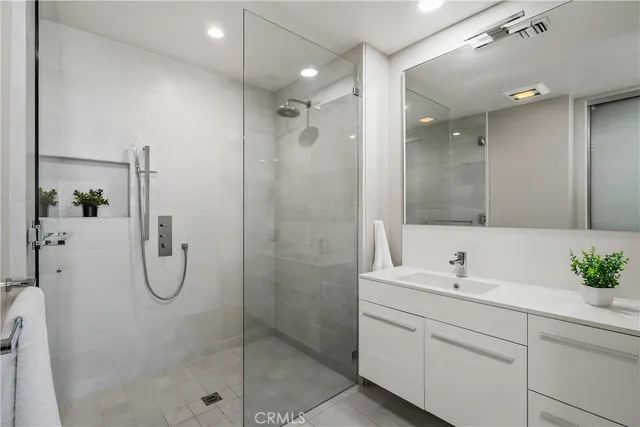 a bathroom with a shower sink and mirror