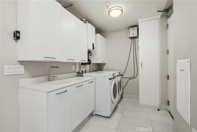 a utility room with cabinets washer and dryer