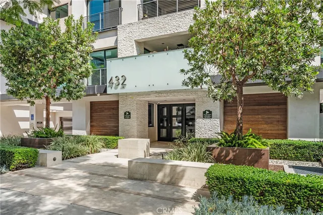 a front view of a house with plants and trees