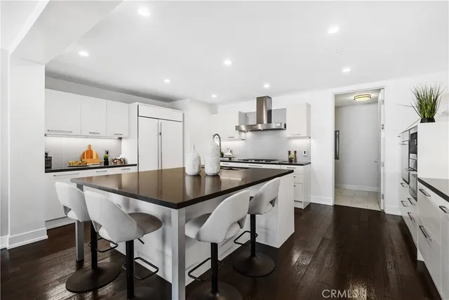 a kitchen with granite countertop white cabinets and stainless steel appliances