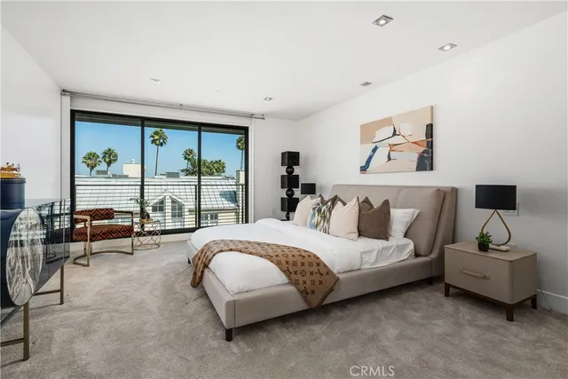 a spacious bedroom with a bed a couch and a large window