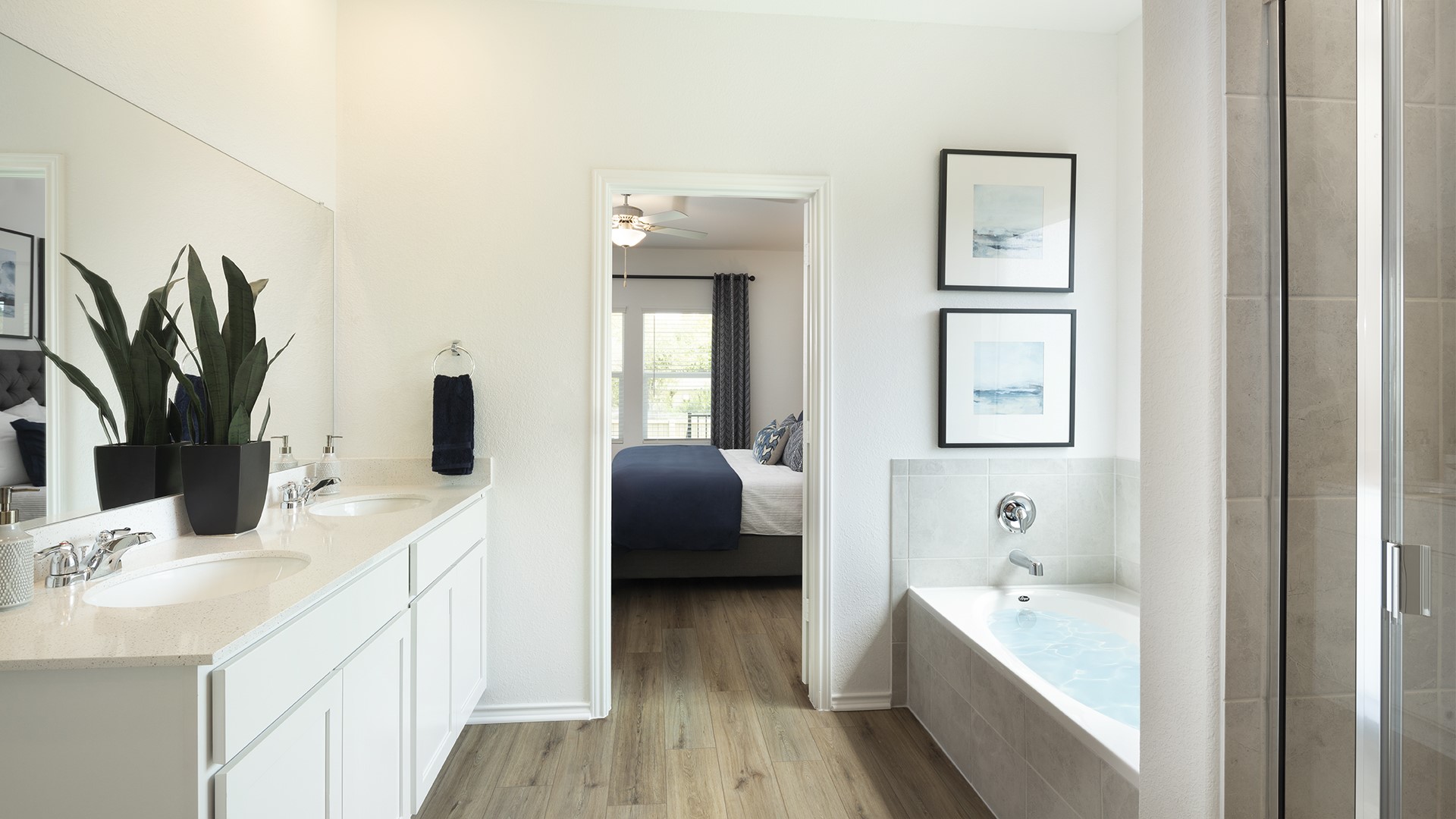 18001 Prairie Falcon Way Pflugerville, TX 78660 - Photo 16 of 18 a en suite bathroom with a double vanity sink a mirror and a bathtub
