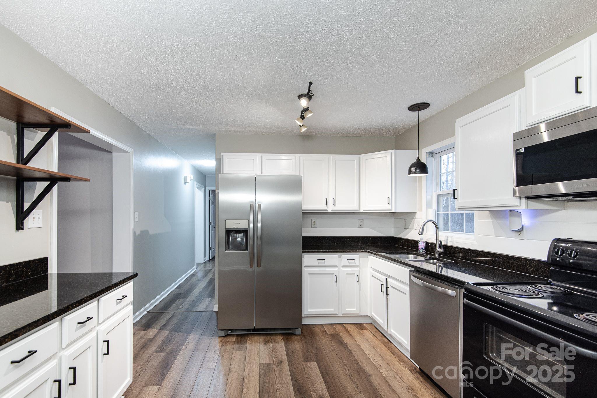263 Newberry Drive Fletcher, NC 28732 - Photo 2 of 29 a kitchen with granite countertop a refrigerator stove and sink