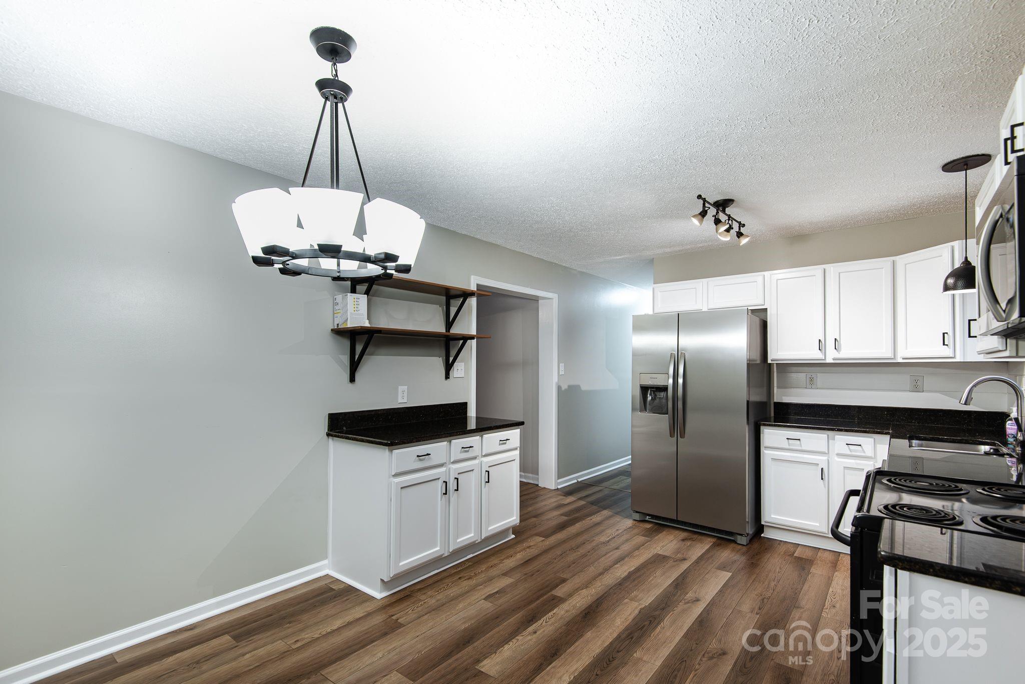 263 Newberry Drive Fletcher, NC 28732 - Photo 27 of 29 a kitchen with stainless steel appliances a stove a refrigerator and a wooden floor