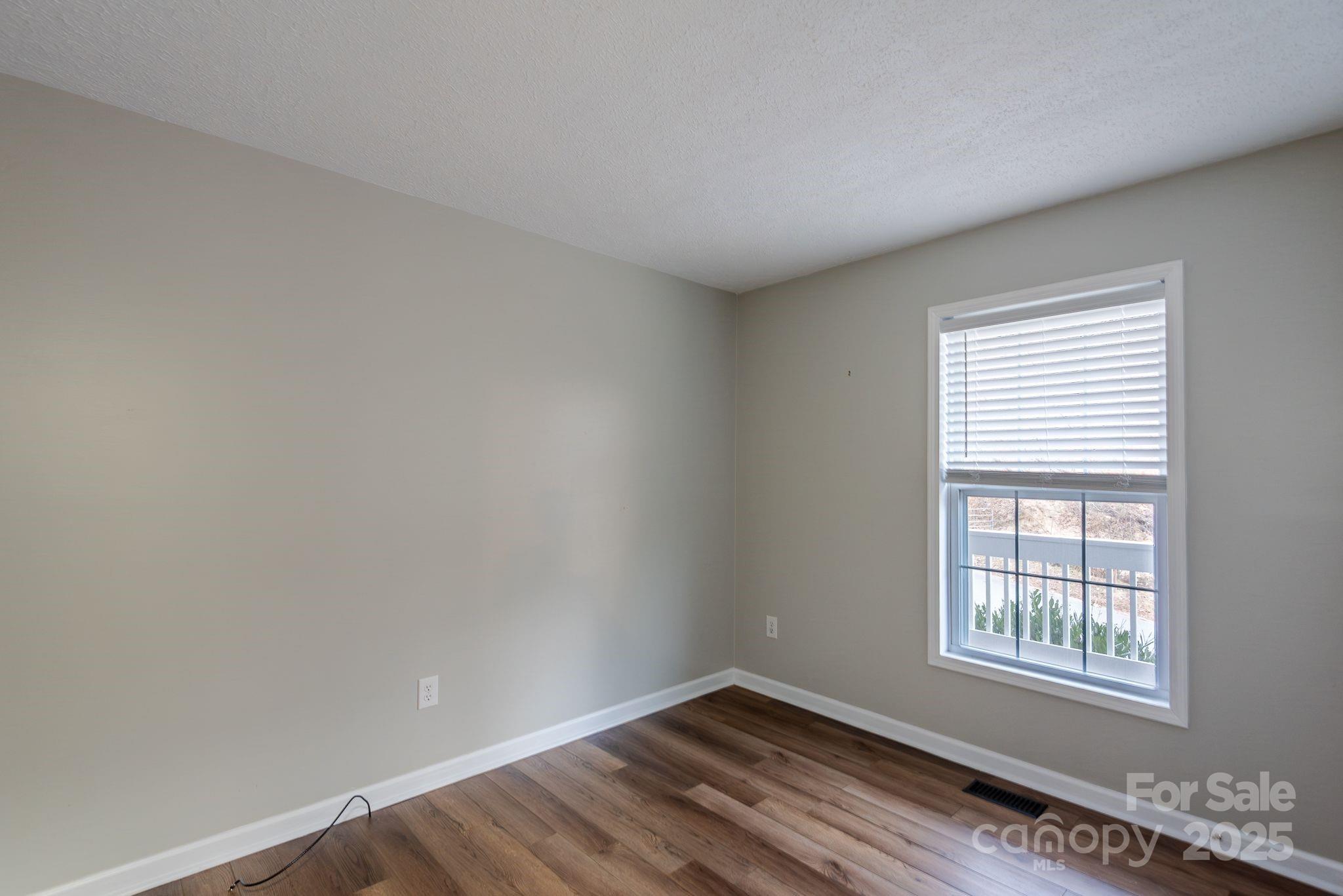 263 Newberry Drive Fletcher, NC 28732 - Photo 9 of 29 a view of an empty room with wooden floor and a window