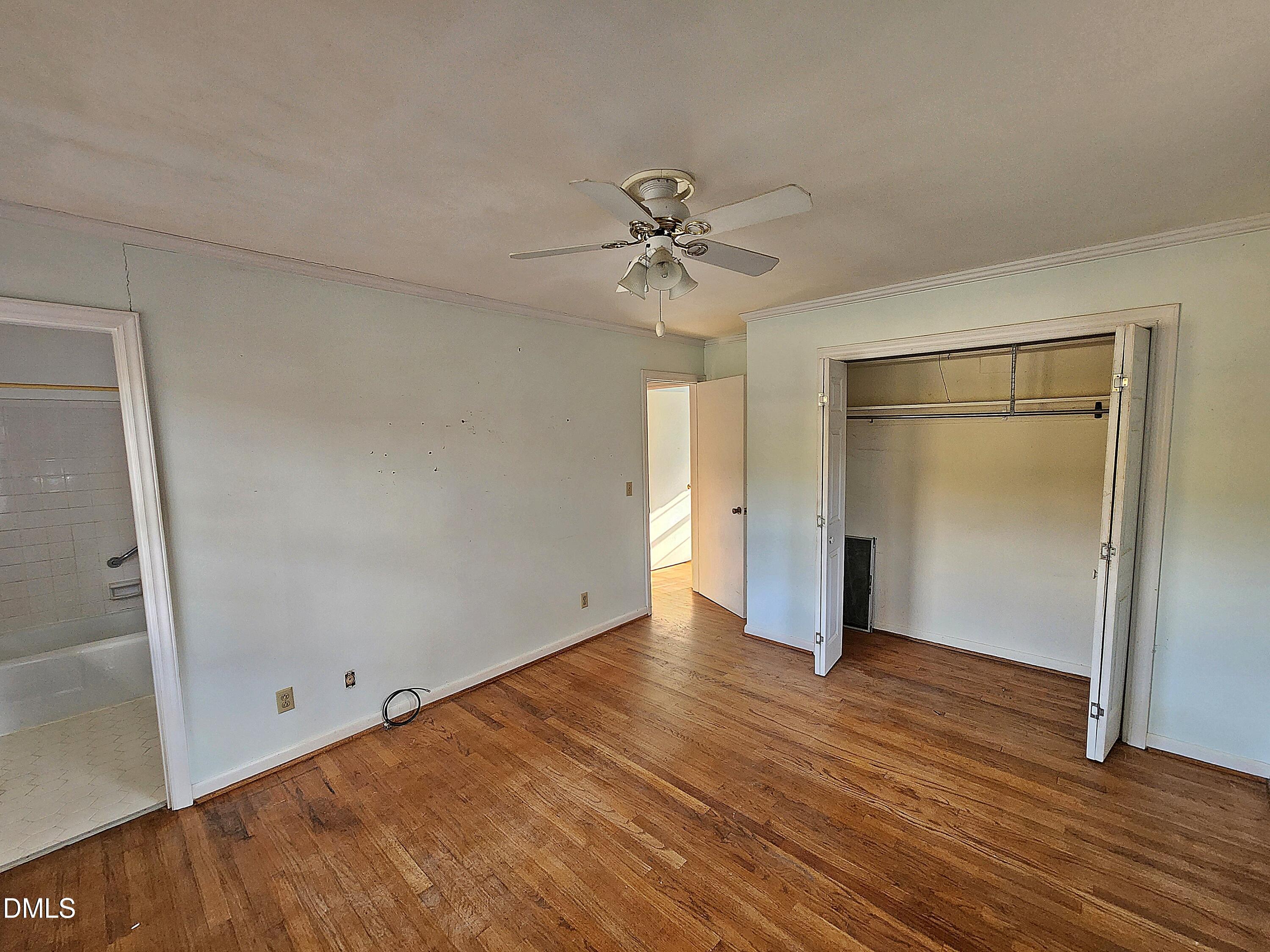 239 Hamilton Road Chapel Hill, NC 27517 - Photo 16 of 30 an empty room with wooden floor and a ceiling fan