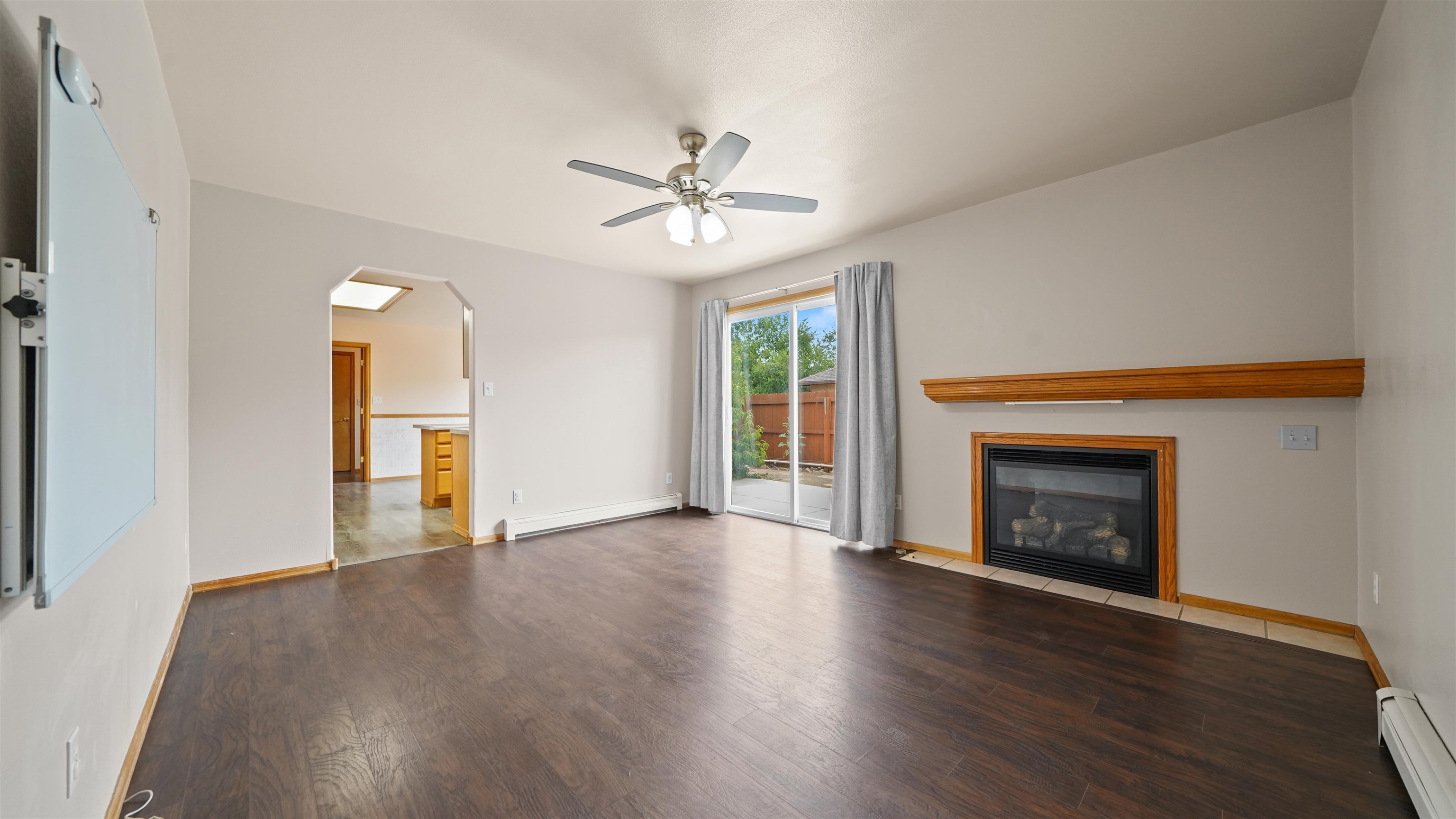 819 Elberta Avenue Palisade, CO 81526 - Photo 3 of 40 an empty room with wooden floor fireplace and windows