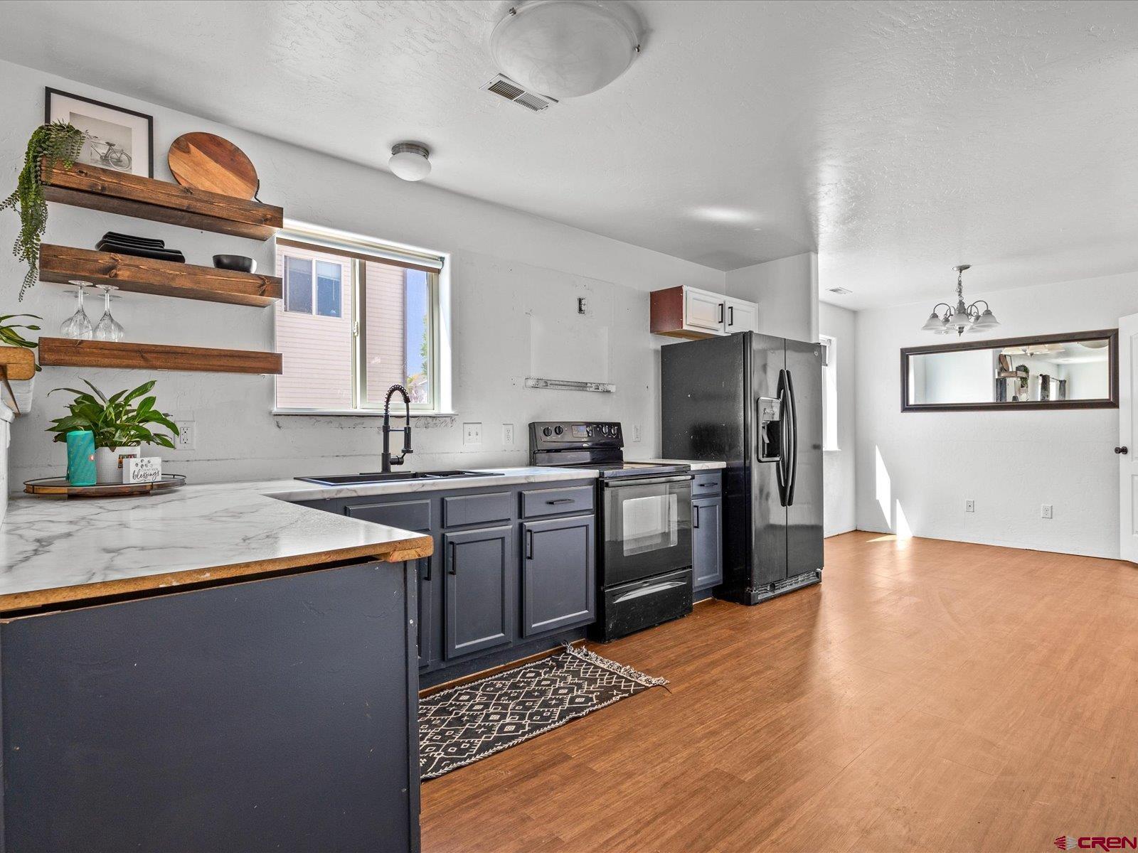 2473 Brookwillow Loop Grand Junction, CO 81505 - Photo 3 of 19 a kitchen with granite countertop a sink stainless steel appliances and white cabinets