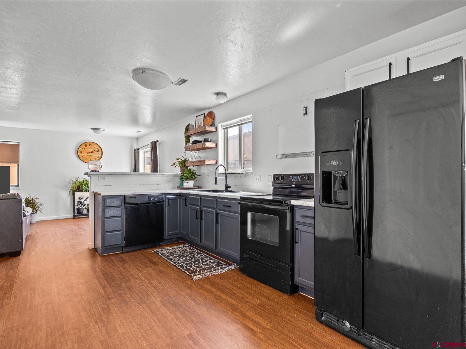 2473 Brookwillow Loop Grand Junction, CO 81505 - Photo 4 of 19 a kitchen with stainless steel appliances granite countertop a refrigerator a stove and a wooden floors