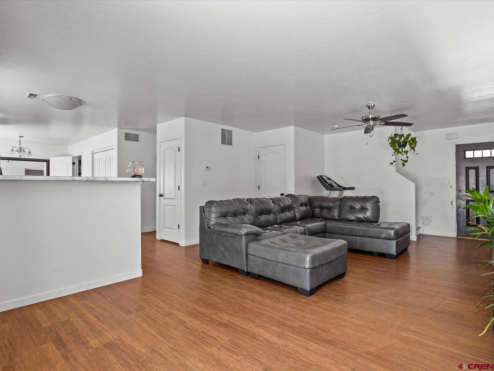 2473 Brookwillow Loop Grand Junction, CO 81505 - Photo 6 of 19 a living room with kitchen island furniture and wooden floor